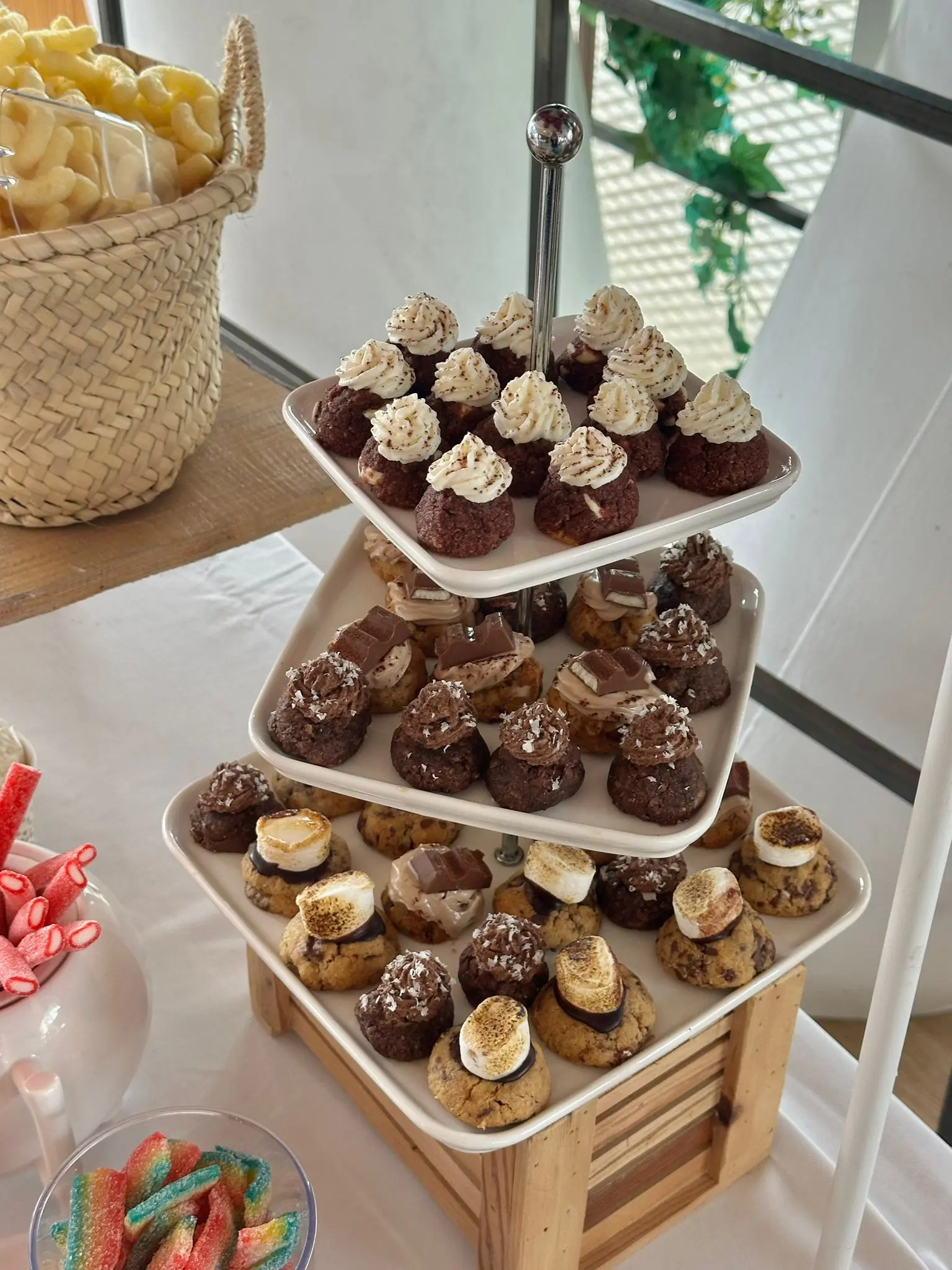 Three-tier tray of artisan gluten-free cookies and biscuits from Glukkies served at a local event, topped with toasted marshmallows, chocolate, and nuts.